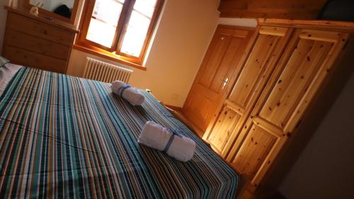 a bedroom with a bed with two towels on it at Dependance GRIMANI in Ampezzo