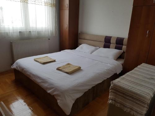 ein Schlafzimmer mit einem Bett mit zwei Handtüchern darauf in der Unterkunft Redon Apartment in Pristina