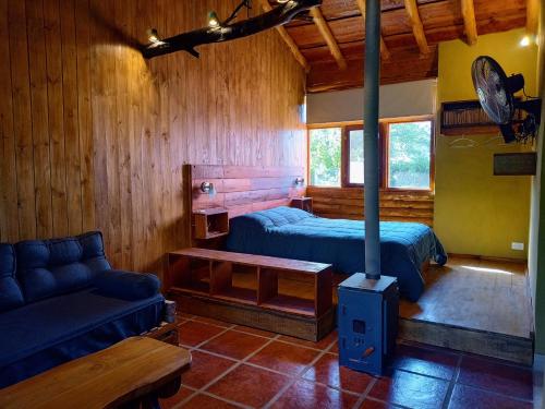 a room with two beds and a couch in a cabin at Cabañas La Ruka in Los Reartes