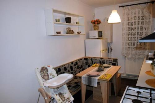 a kitchen with a table and a chair in a room at Apartament Thea in Făgăraş