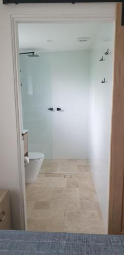 a bathroom with a shower and a toilet in a room at Sandpiper Motel Ulladulla in Ulladulla