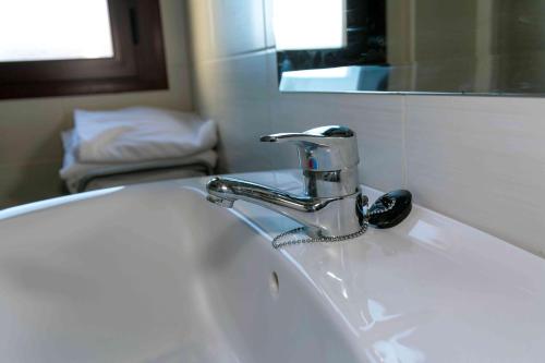 マドリガル・デ・ラ・ベラにあるLA COCHERAの蛇口と鏡が付いたバスルームのシンク