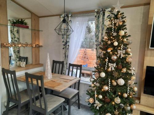 a christmas tree in a dining room with a table at Treehouse - Hot Tub in Newton on the Moor