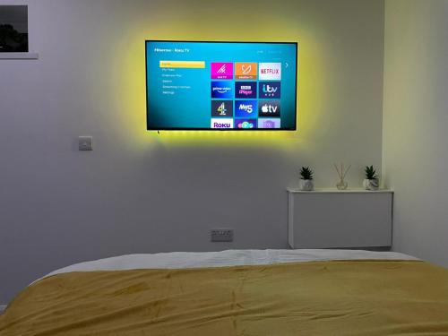 a flat screen tv hanging on a wall above a bed at Balco Sherwood Studio in Nottingham
