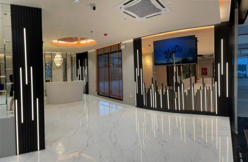 a lobby with white marble floors and a large screen at The Neuf@Ratchada in Bangkok