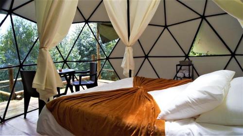 a bedroom with a bed in a room with windows at RESERVA CATEDRAL Glamping in Zipaquirá