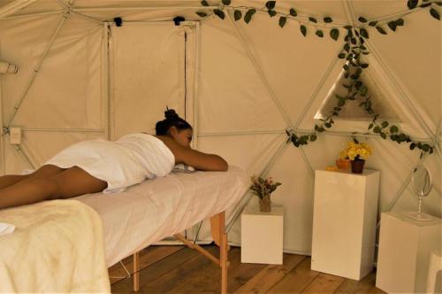 Eine Frau, die in einem Zelt auf einem Bett liegt. in der Unterkunft RESERVA CATEDRAL Glamping in Zipaquirá