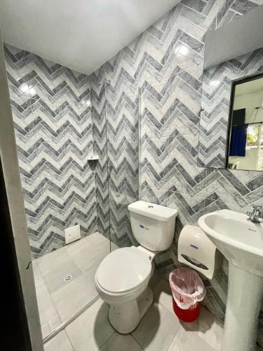 a bathroom with a toilet and a sink at Hotel Y Restaurante La Quinta in Cartagena de Indias