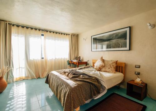 a bedroom with a bed and a large window at Boulenc Bed and Bread in Oaxaca City