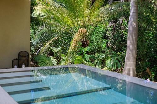 a swimming pool with palm trees in a house at Donna Carmela Resort & Lodges in Riposto