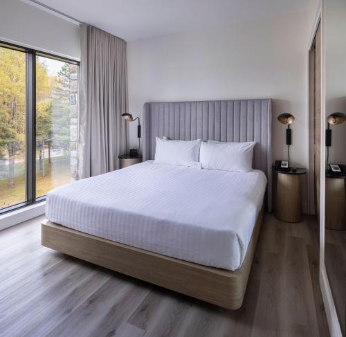 a bedroom with a large bed and a large window at Estérel Resort in Esterel