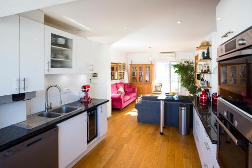 a kitchen with a sink and a living room at Penthouse Antibes apartment in Antibes