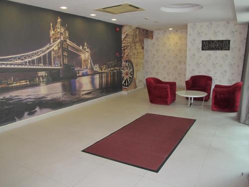 a waiting room with chairs and a table and a painting at Oscar Inn in Petaling Jaya