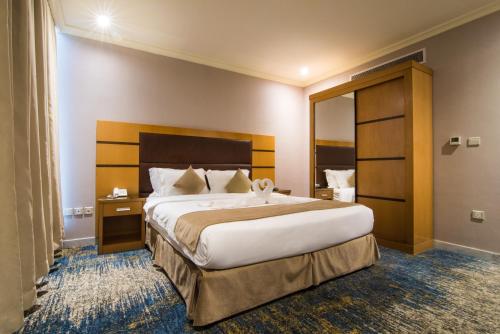 ジッダにあるOzone hotelの大きなベッドと鏡が備わるホテルルームです。