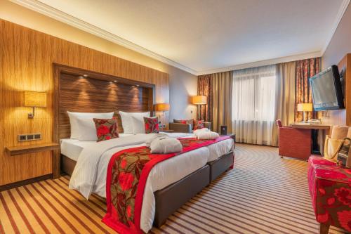 een hotelkamer met een groot bed en een televisie bij DER HEIDEHOF Conference & SPA Resort in Ingolstadt