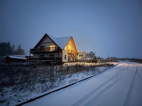a house sitting on the side of a snow covered road at Apartmány MAX in Vaclavov u Bruntalu