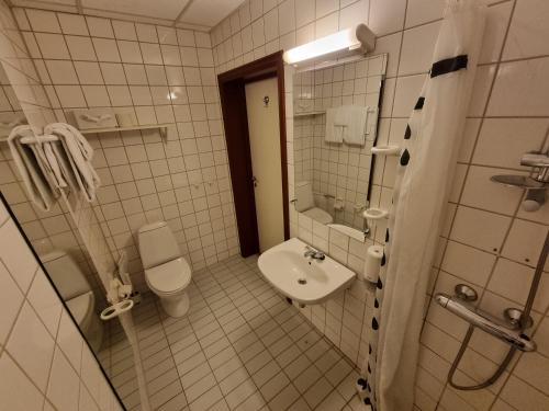 a white bathroom with a toilet and a sink at Chesterfield Hotel in Trondheim
