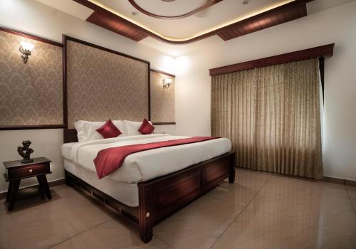 Ein Bett oder Betten in einem Zimmer der Unterkunft Wayanad Mace Mansion
