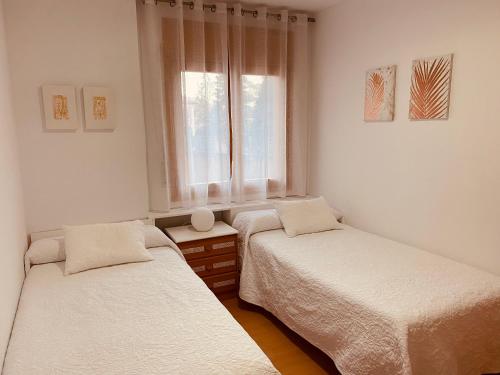 - 2 lits dans une chambre avec fenêtre dans l'établissement Apartamentos Alcañiz, Gala, à Alcañiz
