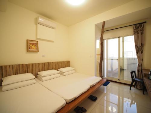 una camera da letto con due letti e una finestra di Plum Green Homestay a Jinning