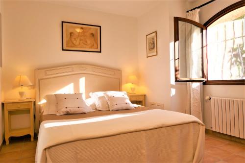 ヴァンスにあるGite les Citronniersのベッドルーム1室(白いシーツ付きのベッド1台、窓付)