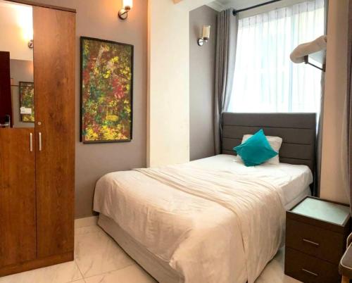 a bedroom with a bed and a painting on the wall at Dhimyaath Stay in Male City