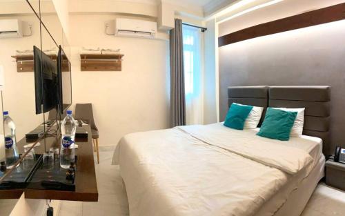 a bedroom with a bed with a desk and a television at Dhimyaath Stay in Male City