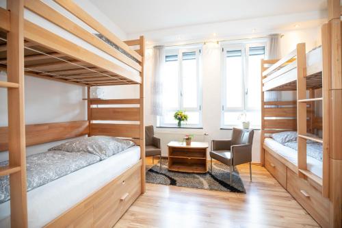 a room with two bunk beds and a desk at Hostel WohnZimmer-Essen in Essen