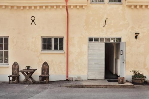 a building with a door and a table and two chairs at Hotel Helgeand Wisby in Visby