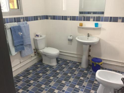a bathroom with a toilet and a sink at Maison MIDAREA in Kribi