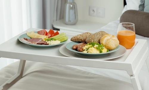 a table with two plates of food and a glass of orange juice at Mały Sopot Boutique in Iława