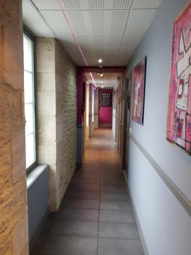 a corridor in an office building with a long hallway at Hotel restaurant La Pêcherie - Le manoir d'à coté - Les 5 ruches -Logis hôtels in Courseulles-sur-Mer