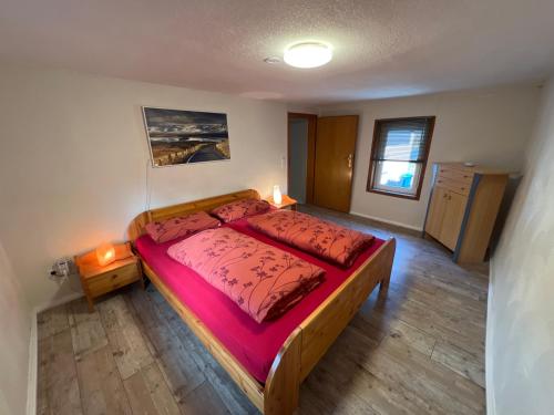 - une chambre avec un grand lit et des draps rouges dans l'établissement 300 Jahre altes renoviertes Fachwerkhaus, à Peterslahr