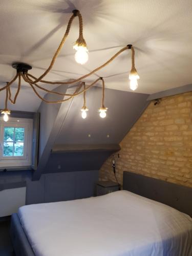 a bedroom with a bed with lights on the ceiling at Hotel restaurant La Pêcherie - Le manoir d'à coté - Les 5 ruches -Logis hôtels in Courseulles-sur-Mer