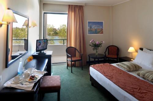 una camera d'albergo con un letto e un tavolo con cibo sopra di Margarona Royal Hotel a Preveza
