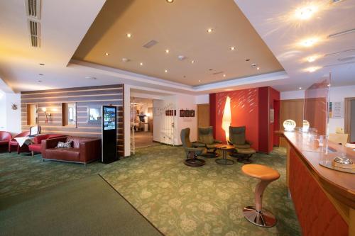 a hotel room with a lobby with a living room at Hotel Vitaler Landauerhof in Schladming