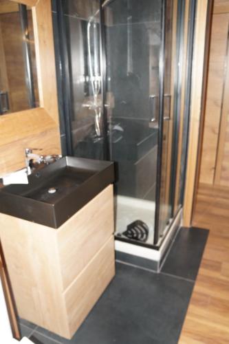 a bathroom with a shower and a black sink at ROYAL SUITE TOTTO'NETTA 504 in Passo del Tonale