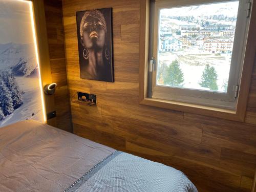 Schlafzimmer mit einem Fenster mit Bergblick in der Unterkunft ROYAL SUITE TOTTO'NETTA 504 in Passo del Tonale