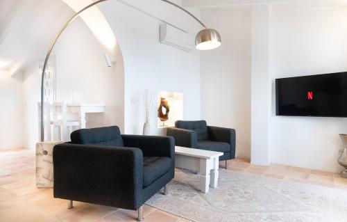 a living room with two chairs and a tv at Porta Nova Suites - Room Breakfast & Sea View in Altea