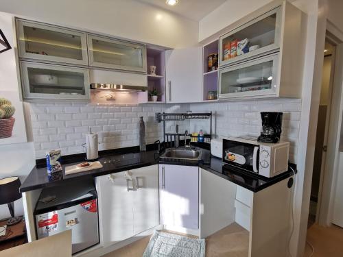 a kitchen with a counter with a sink and a microwave at Avida Davao by davaobnb & Lemonique Homes in Davao City