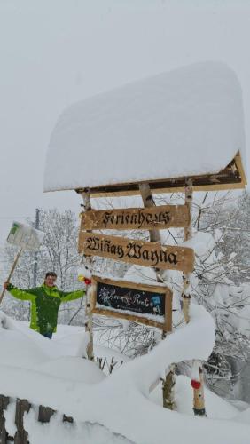 a person standing next to a sign in the snow at Ferienhaus & Ferienwohnung Wiñay Wayna Gotschna Blick Klosters in Klosters Serneus