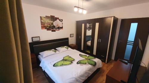 a bedroom with a bed with leaves on it at Apartament Coșbuc in Baia Mare