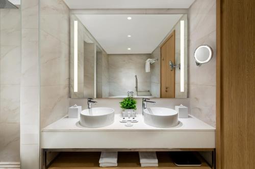 a bathroom with two sinks and a mirror at Millennium Place Mirdif in Dubai