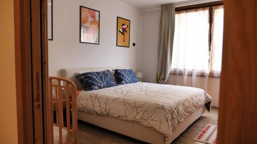 a bedroom with a bed with blue pillows and a window at Al vecchio arcolaio in Bormio