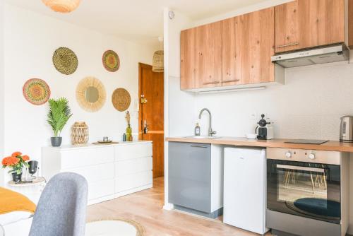 une cuisine avec des armoires en bois et un comptoir dans l'établissement Lumineux - L'Authentique - Centre, à Haguenau