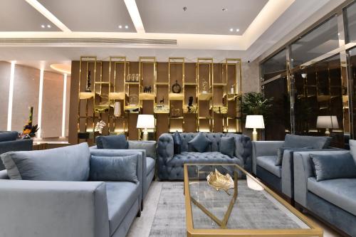 a living room with blue couches and a table at JUFFAIR BOULEVARD HOTEL & SUITES in Juffair
