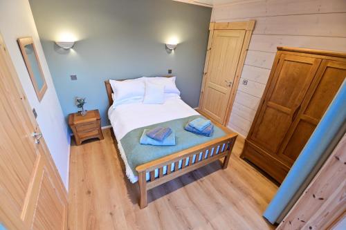 a bedroom with a bed with two towels on it at Cuddfan Lodge on a Beautiful Lake in Newport
