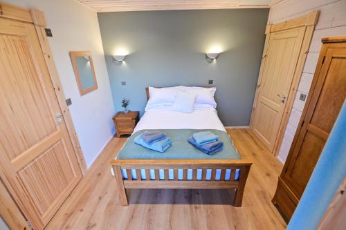 a small bedroom with a bed with two towels on it at Cuddfan Lodge on a Beautiful Lake in Newport