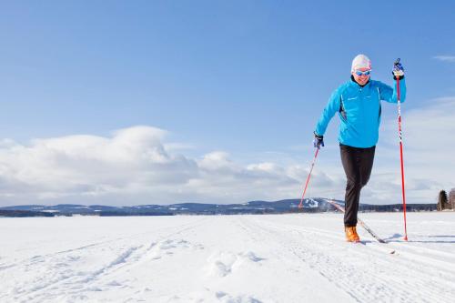 a woman is cross country skiing in the snow at Haapala Brewery restaurant and accommodation in Vuokatti