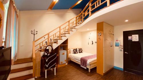 een slaapkamer met een bed en een trap bij Hai Yang Feng Qing Homestay in Hualien